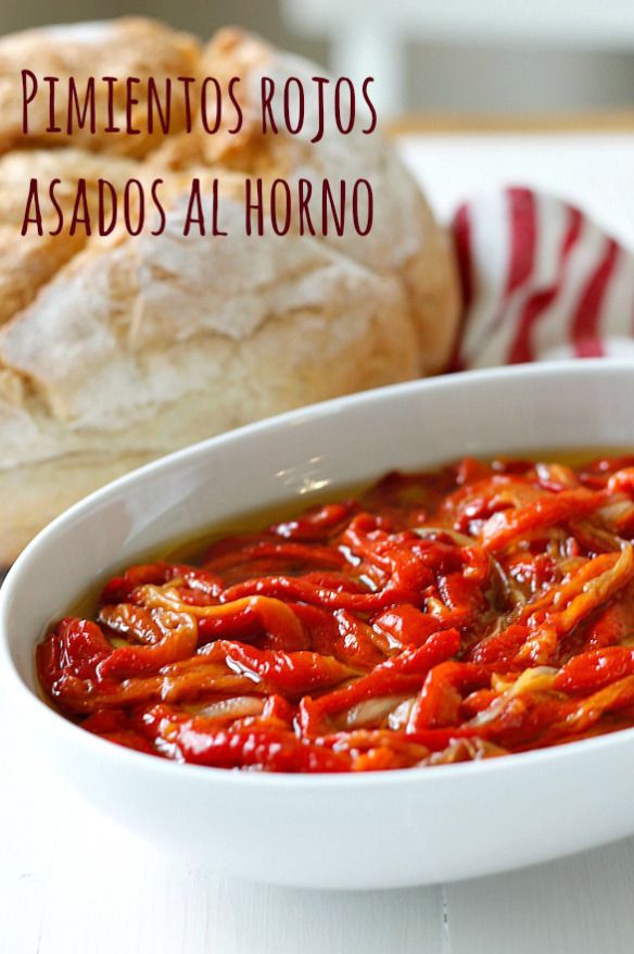 a white bowl filled with red sauce next to bread