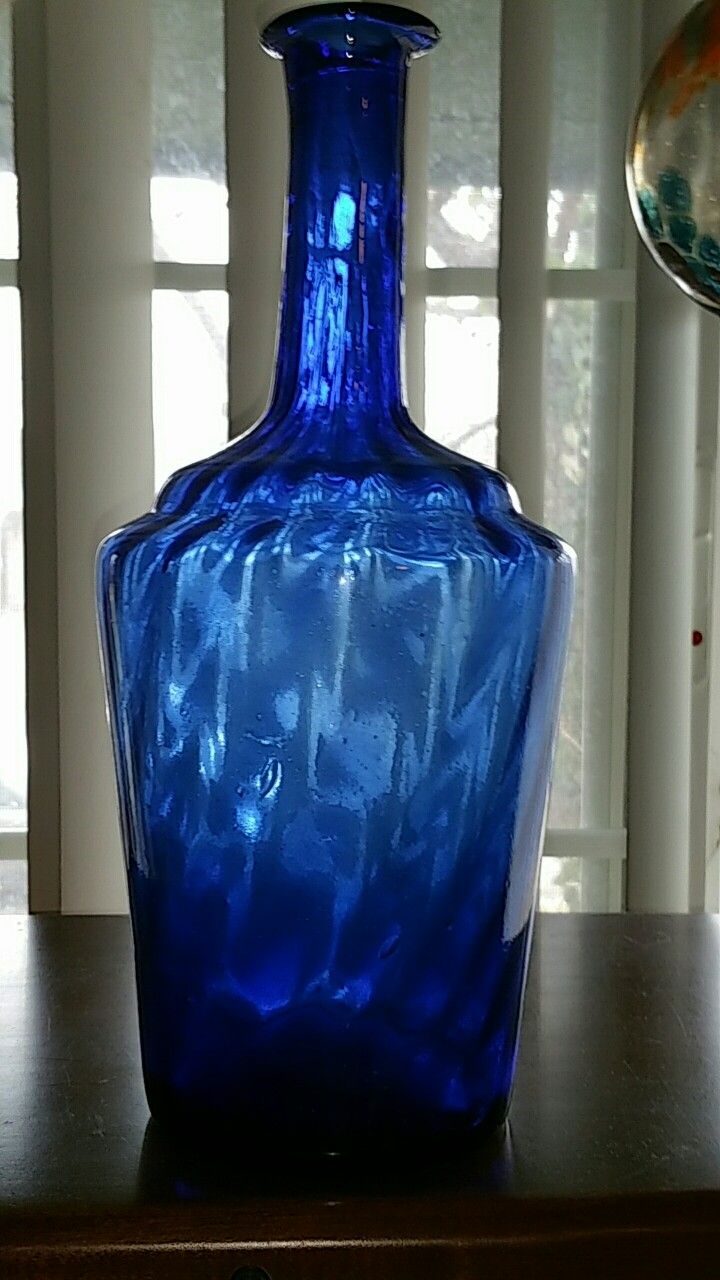 a blue vase sitting on top of a wooden table