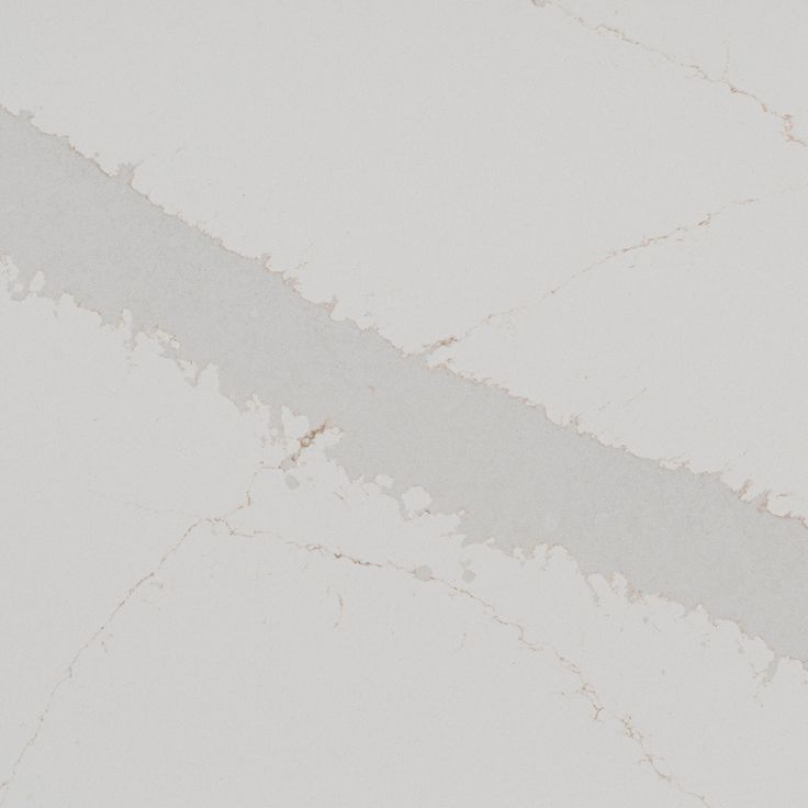 the corner of a white marble wall with peeling paint on it's edges and an orange object in the foreground