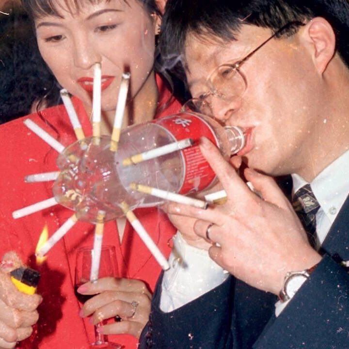 a man and woman are blowing out candles on their face as they stand in front of each other