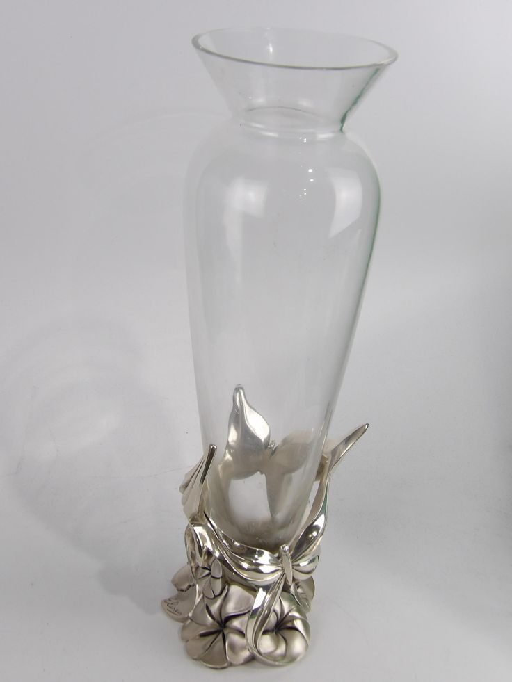 a clear glass vase with silver flowers in it