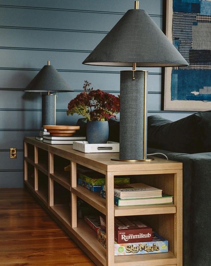 a living room with two lamps and a book shelf