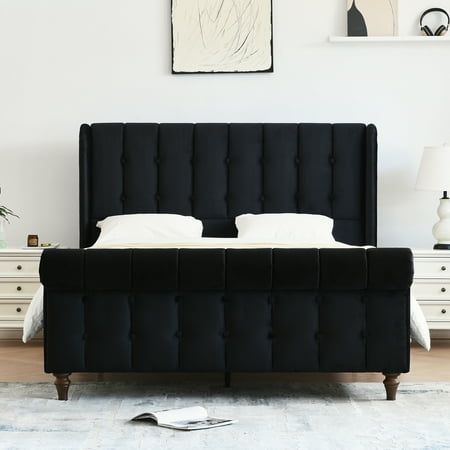 a black bed with white sheets and pillows