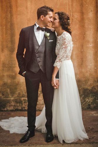 a man in a tuxedo and a woman in a wedding dress standing next to each other