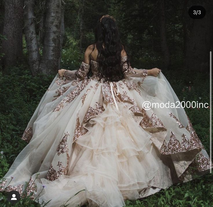 a woman in a wedding dress is walking through the woods with her back to the camera