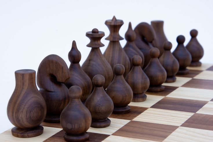 a wooden chess board with several pieces on it