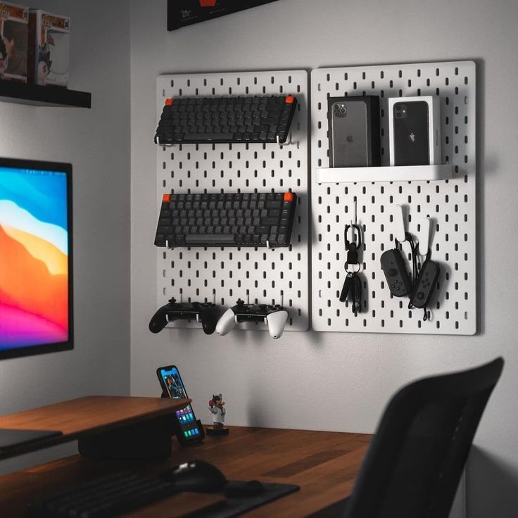 a computer desk with a monitor and keyboard on the wall next to it is a black chair