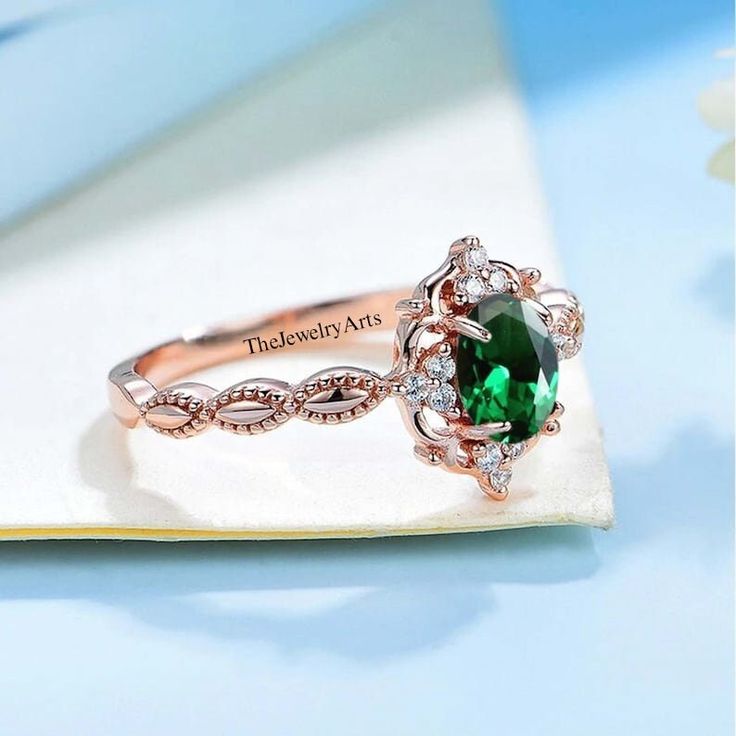 a close up of a ring with a green stone in the center on a napkin