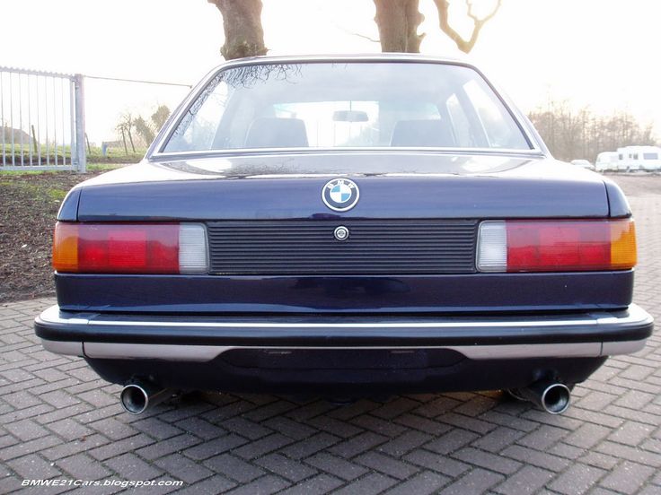 the rear end of a blue car parked in a driveway