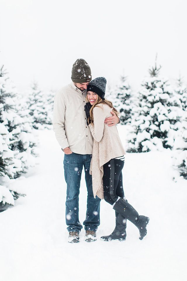 a man and woman are standing in the snow with their arms wrapped around each other