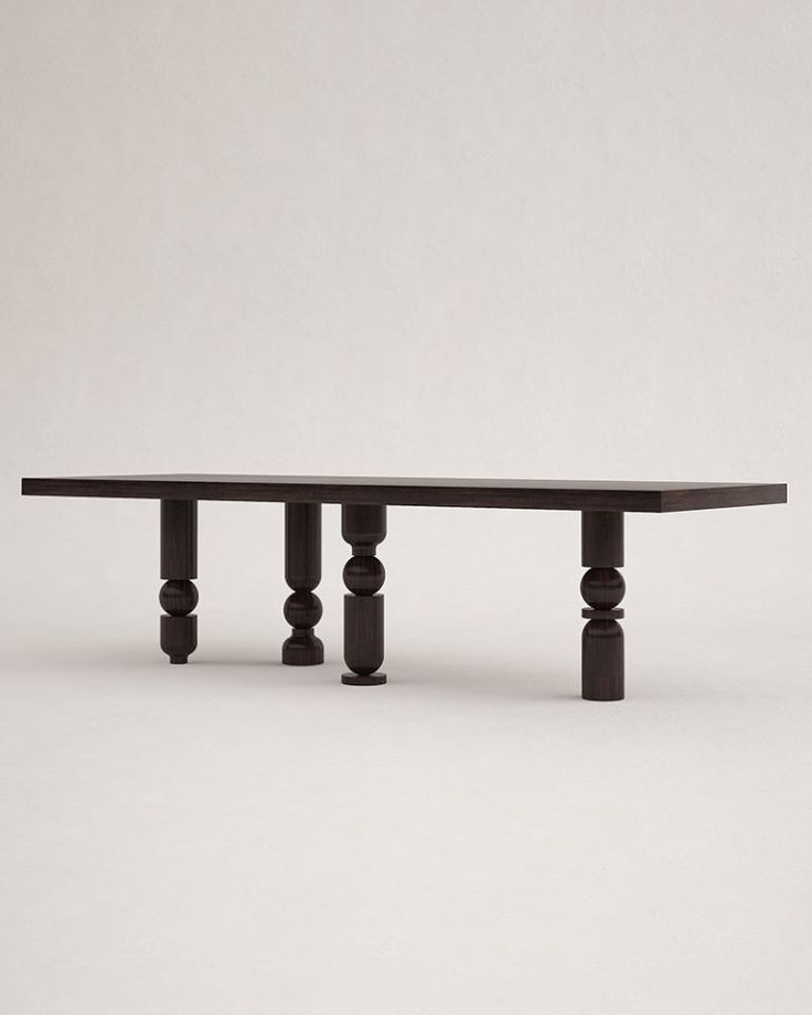 a black table sitting on top of a white floor next to a gray wall with columns