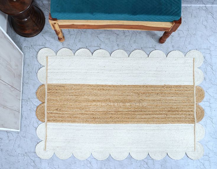 a white and brown rug sitting on top of a floor next to a blue chair