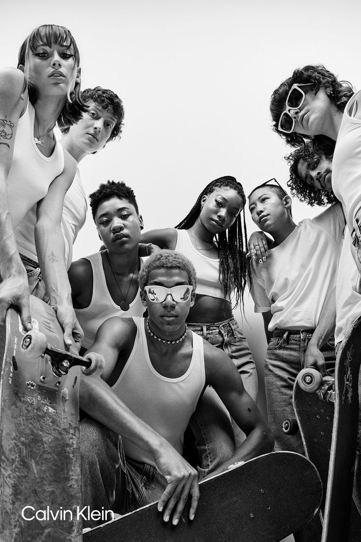 a group of young people standing next to each other with skateboards in their hands