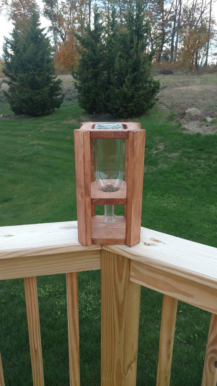 an empty glass on top of a wooden railing