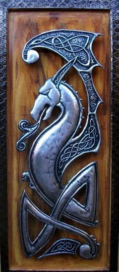 a metal plaque with an image of a dragon on it's face and two swords in its mouth