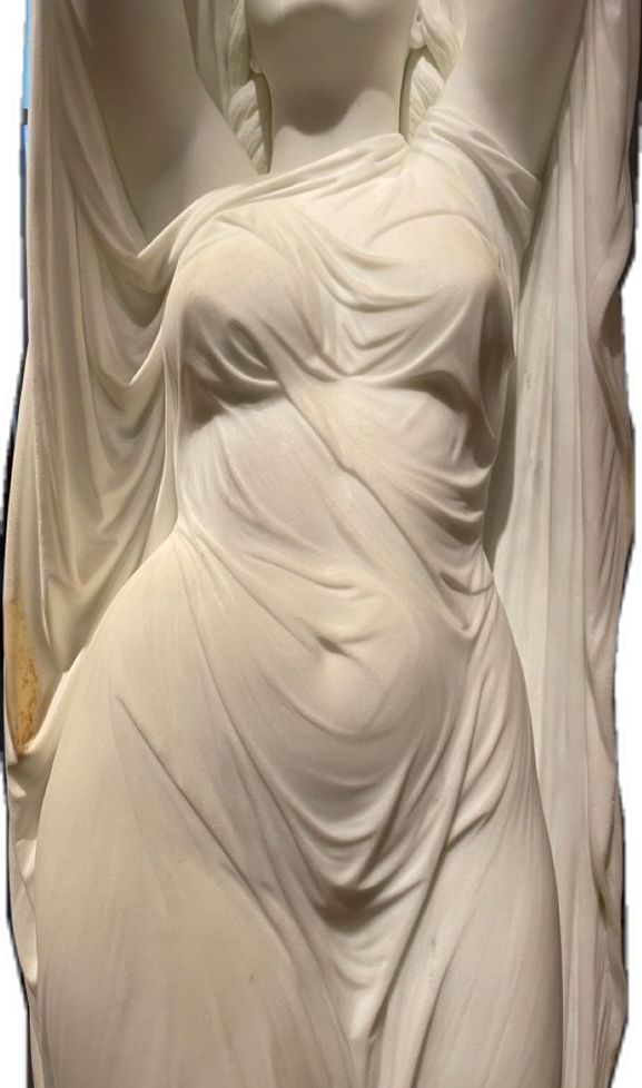 a sculpture of a woman in white draped dress with her hands behind her back and head tilted to the side