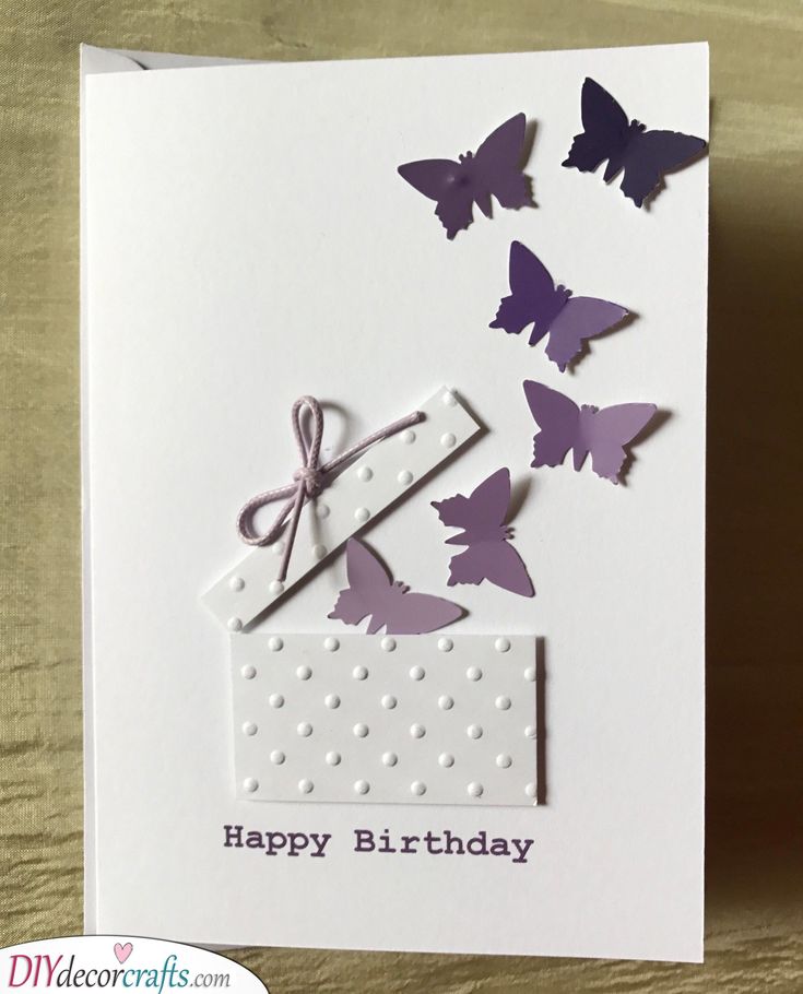 a birthday card with purple butterflies and a gift box on it's side that says happy birthday