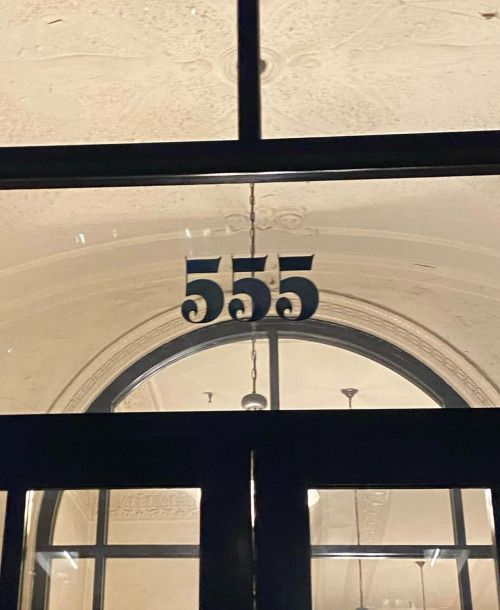 an open door with the number 555 on it's side and glass windows