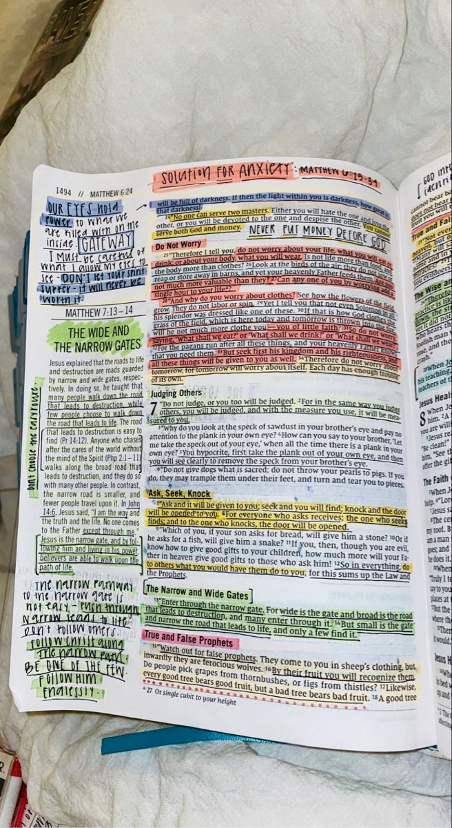 an open book with colorful text on it sitting on top of a white sheeted surface