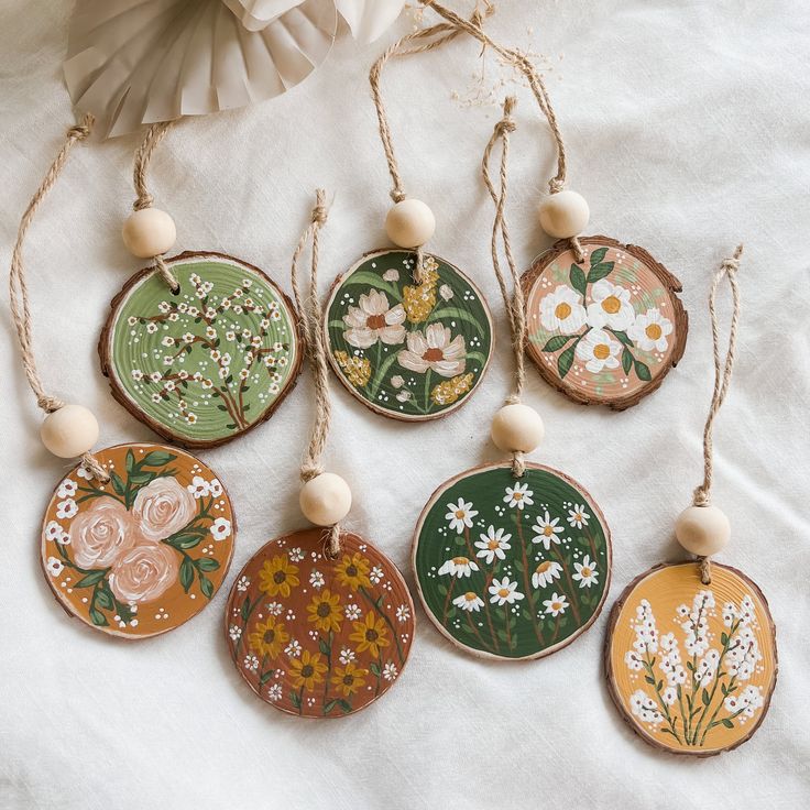 six hand painted wooden ornaments with flowers on them