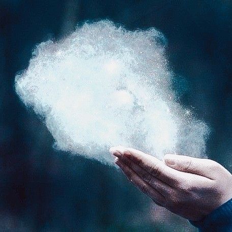 a person holding something in their hand with white powder coming out of the top of it