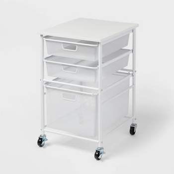 three drawers with wheels on each side and two baskets on the bottom, all in white