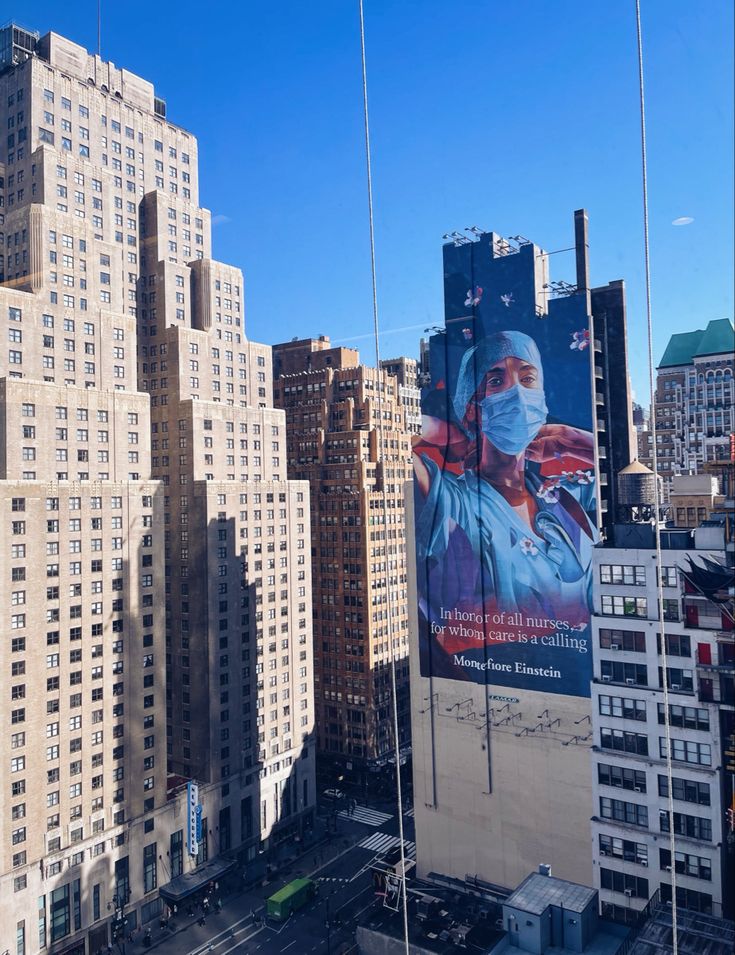 a city skyline with tall buildings and large billboards on the building's sides