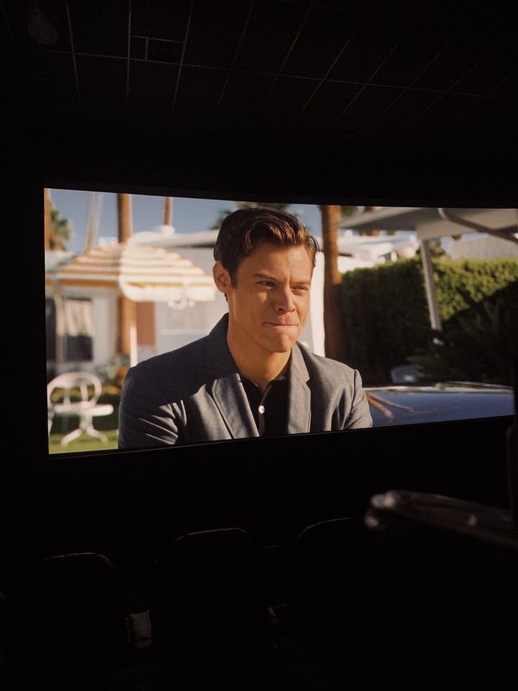 a man sitting in front of a tv screen