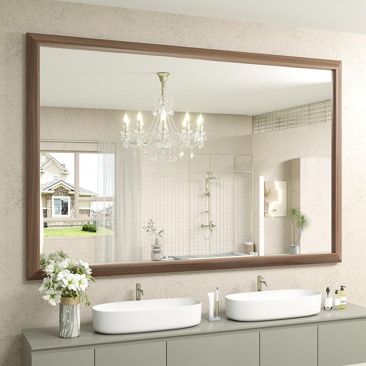 a bathroom with two sinks and a large mirror on the wall above it, along with a chandelier