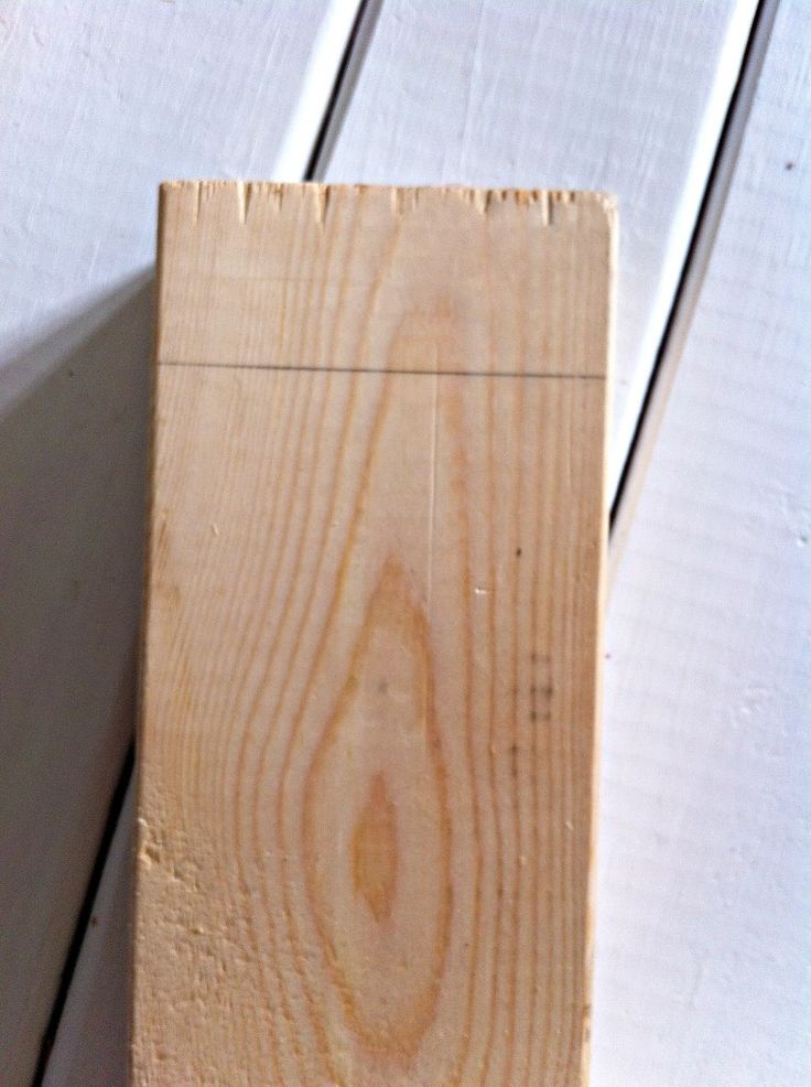 a piece of wood sitting on top of a wooden floor next to a white wall