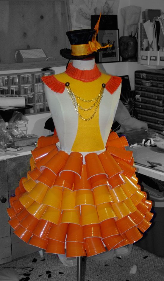 an orange and white dress on a mannequin in a room with other items