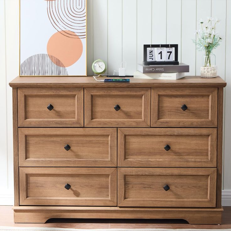 a wooden dresser sitting in a room next to a clock