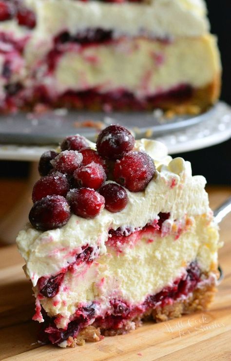 a piece of cheesecake with cranberries and whipped cream