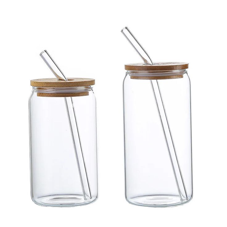 two glass jars with wooden lids and metal straws