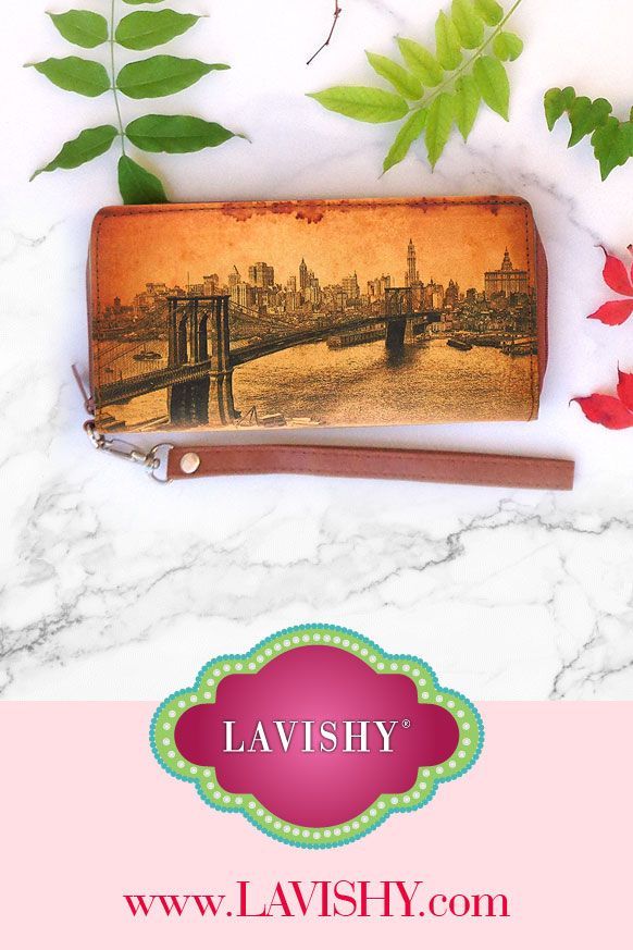 a purse with the name lavish on it next to flowers and leaves in front of a white marble background