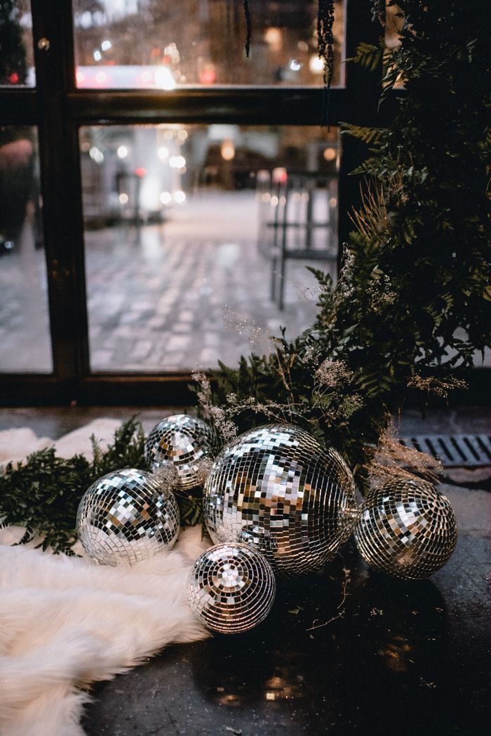 disco balls and greenery on the floor in front of a window