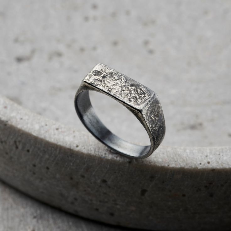 This stylish Men's Signet Ring is handmade by our expert jewellers in the heart of Brighton. Cast from solid sterling silver and due to the process our jewellers use, each ring is unique, much like 'molten'. The ring features a textured oxidised sterling silver rectangle bezel. Each ring is handmade by our skilled artisan jewellers in our Brighton workshop. The bezel of the signet ring measures 1. 3cm across. Ring width 5. 5mm. Please specify your ring size (this is the standard UK letter ring size). Handmade in oxidised 925 sterling silver Handmade in oxidised 925 sterling silver. Each item is individually handmade to order in our Brighton workshop. All of our items are handmade so please check that all personalisation, sizing, product options and delivery information have been entered co Men Signet Ring, Russian Ring, Posh Totty, 6 Characters, Handmade Gifts For Men, Signet Ring Men, Letter Ring, Silver Signet Ring, Dope Jewelry