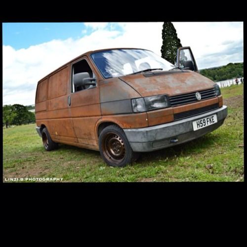 an old van is parked in the grass