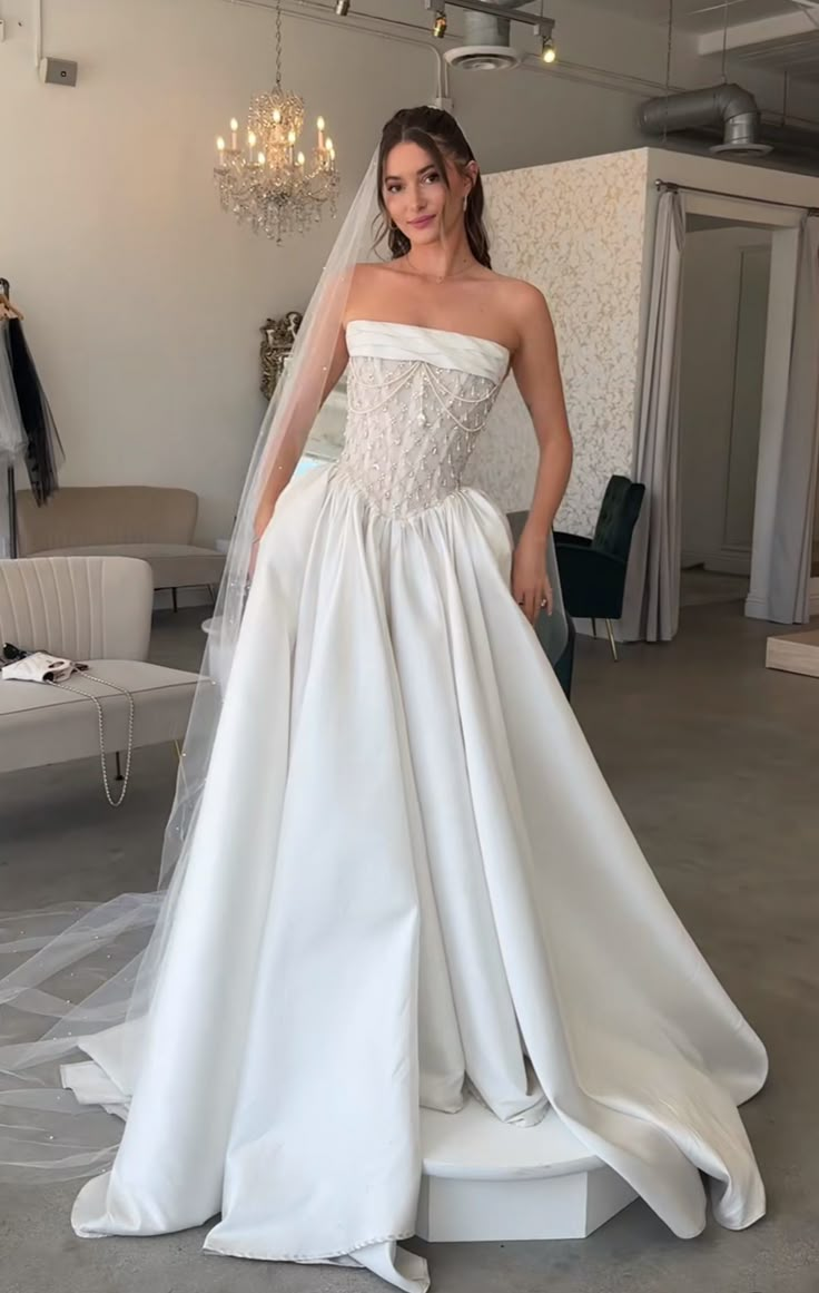 a woman in a white wedding dress posing for the camera