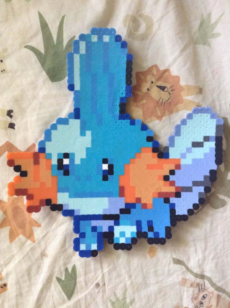 an image of a blue bird made out of legos on a bed with flowers