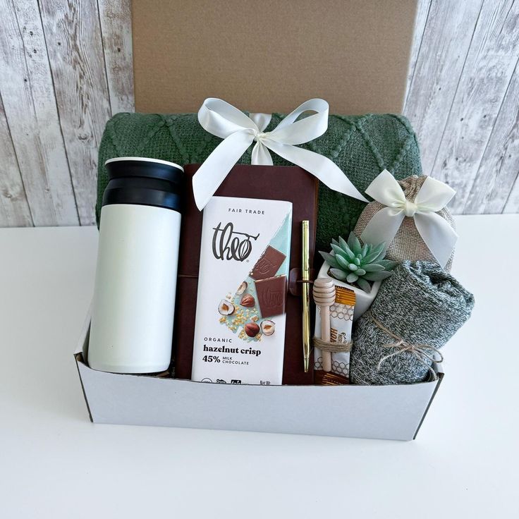 a gift box with coffee, chocolates and other items in it on top of a table