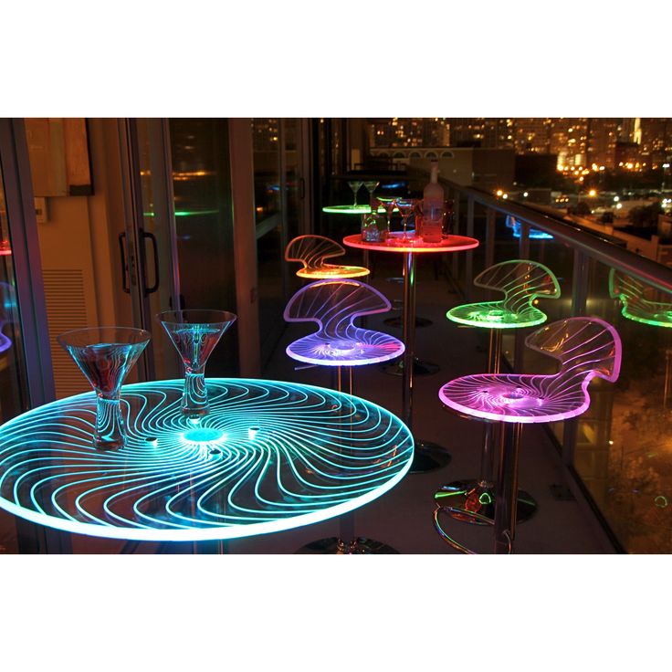 an illuminated table and chairs on top of a building