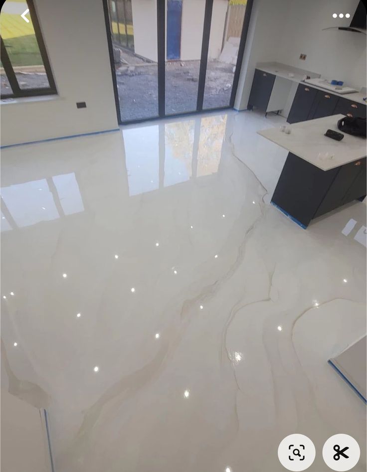 a kitchen with white marble floors and cabinets