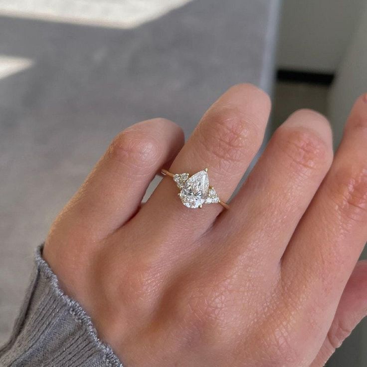 a woman's hand with a diamond ring on it