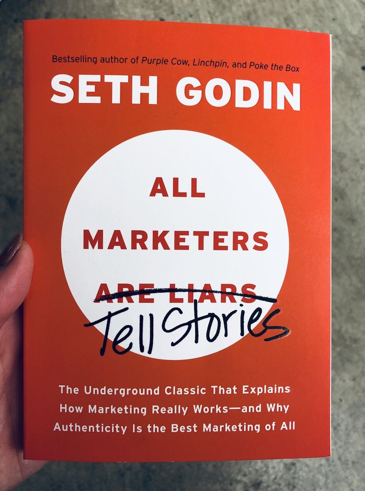 a person holding up a book with the title all marketers are liars tell stories