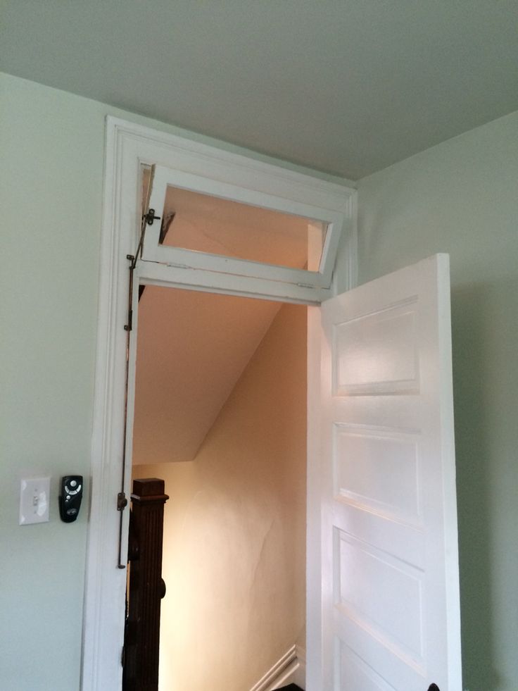 an open door leading to a room with white walls and carpeting on the floor