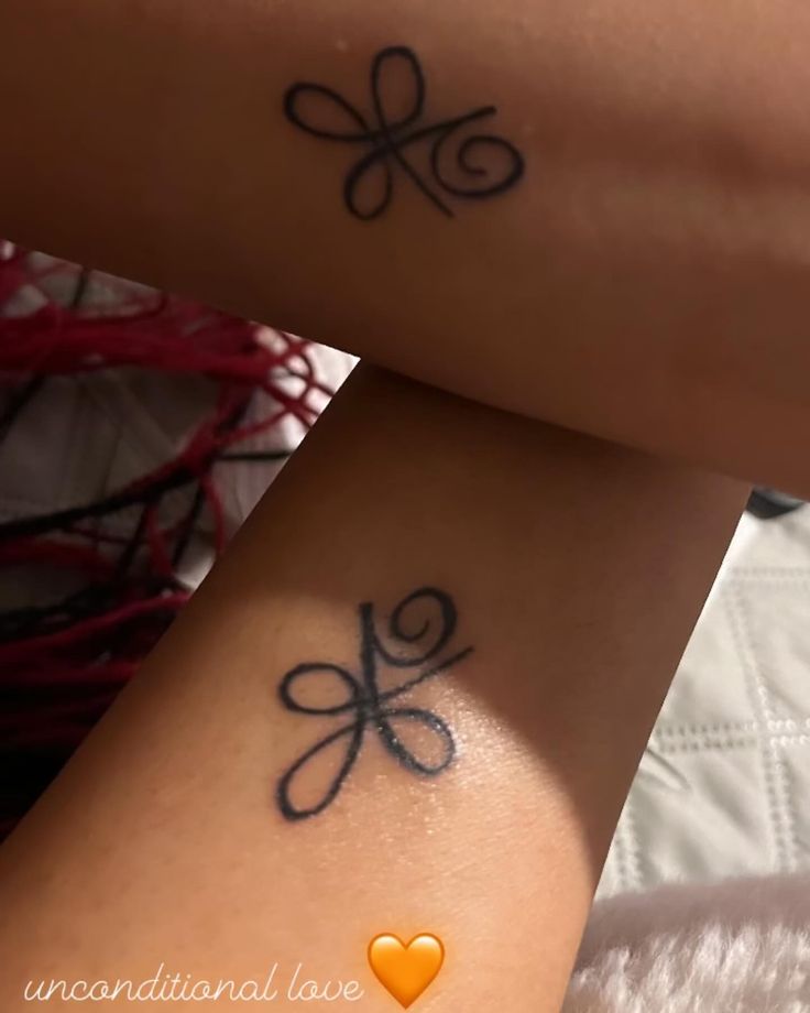 two people with tattoos on their arms and legs, one has an orange heart in the middle