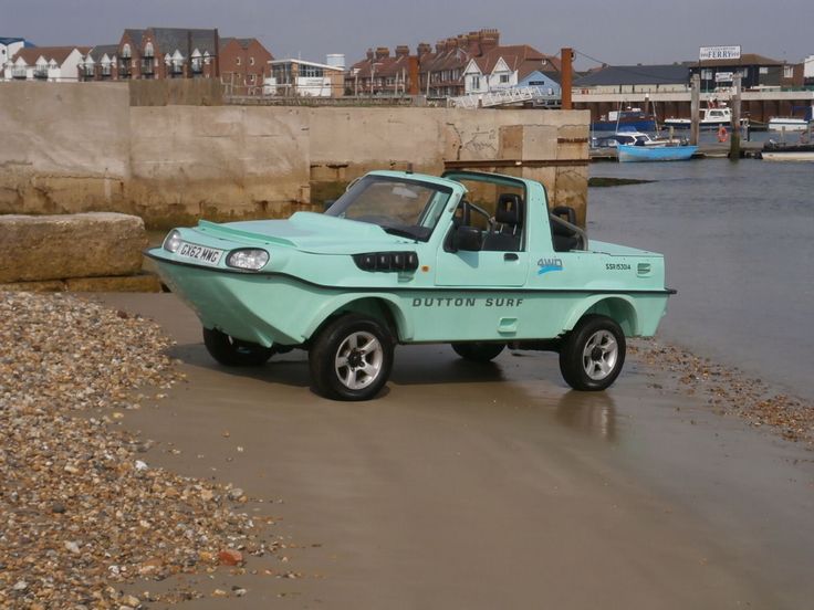 a blue truck parked on top of a sandy beach