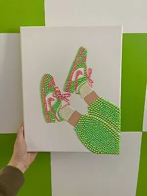 a person holding up a piece of art that has been made to look like someone's feet