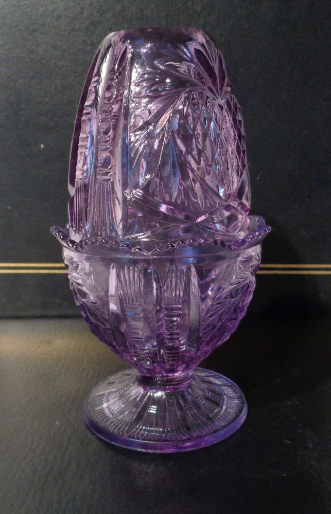 a purple glass vase sitting on top of a table